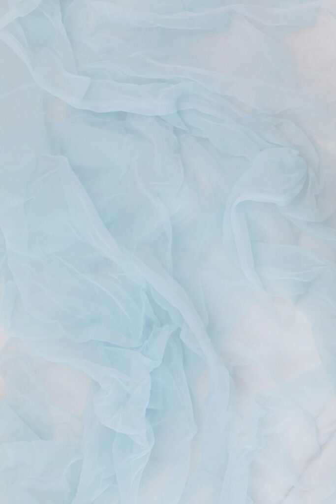 A soft and elegant rippled baby blue fabric texture, perfect for backgrounds or wallpapers.